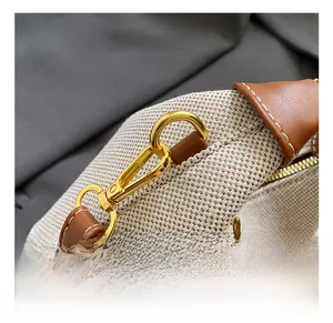 Close-up of durable canvas stitching and high-quality gold metal lobster clasp on the bag