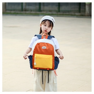 Detail of color-block kids backpack showing orange handle and contrast side pockets
