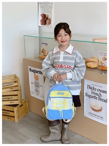 Front detail of tri-color kids backpack with blue, yellow and white color-blocking straps