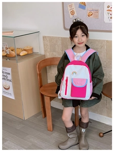 Detailed shot of kids rainbow backpack with colorful panels and embroidery in a cafe