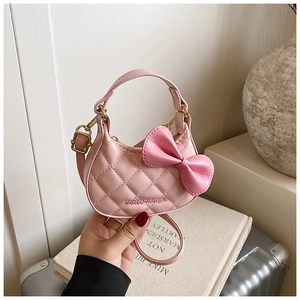 Vue détaillée du mini sac à main rose matelassé avec nœud décoratif et détails dorés