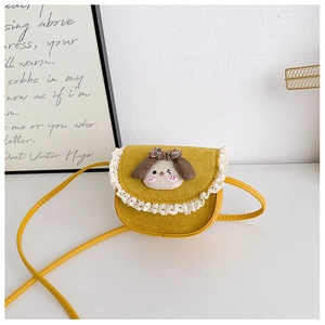 Dettaglio borsa a tracolla per bambini in camoscio giallo con pizzo bianco e ciondolo peluche