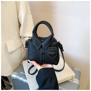 Detailed view of black mini bag in shirt silhouette featuring lapels and buttons