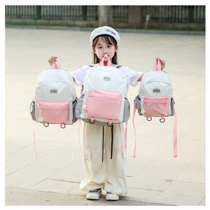 Three sizes of color-block kids backpacks in pink, white and grey on outdoor ground