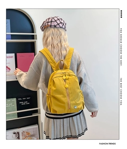 Detail view of a bright yellow kids backpack featuring a durable multi-pocket design