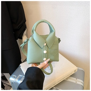 Detail of creative shirt-shaped green mini crossbody bag with collar and button accents
