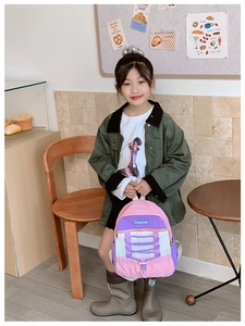 Detail of color-block kids backpack with Fasbag logo and decorative purple drawstrings