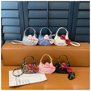 Détail de mini sacs bandoulière avec nœuds géants en plusieurs couleurs et textures