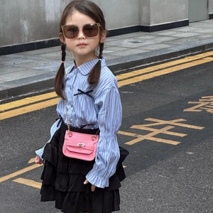 Tenue de mode pour fille avec chemise rayée bleue, jupe noire et sac à chaîne rose