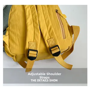 Detail of wide adjustable straps and side zipper pocket on yellow nylon backpack