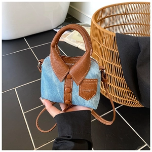 Detail of creative denim shirt style mini bag with brown leather stitching and buttons
