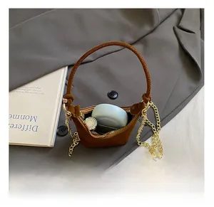 Détail de l'intérieur du mini sac en daim marron avec rouge à lèvres et maquillage