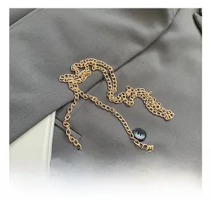 Détail du sac en cuir marron avec chaîne dorée et fermoir rotatif métallique