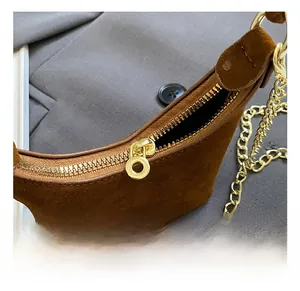 Détails d'un sac à main enfant en cuir mat marron avec chaîne dorée et fermeture éclair
