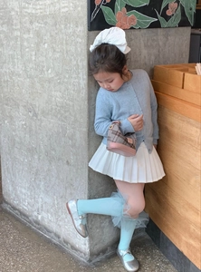 Detailed view of child fashion set with blue cardigan, plaid handbag and Mary Jane shoes