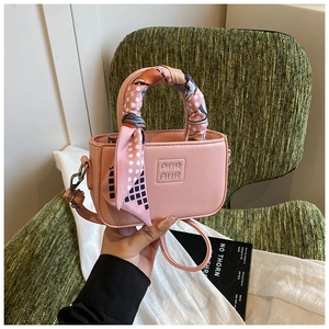 Dettaglio borsa rosa per bambina con logo in rilievo e manico decorato con foulard