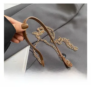 Détail du mini sac en cuir marron avec bandoulière chaîne dorée et fermoir pivotant