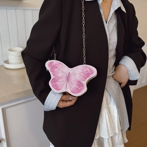 Sweet pink butterfly shoulder bag for girls with delicate gold chain worn over a white dress