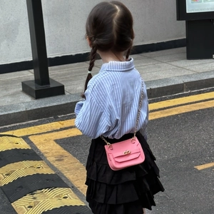 Mini sac bandoulière rose pour filles avec chaîne dorée porté par un enfant