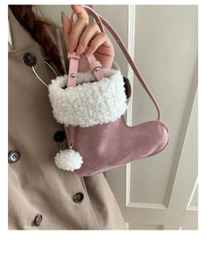 Detail of pink suede boot-shaped handbag with white faux fur trim and fluffy pompom