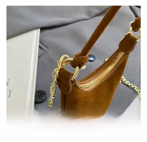 Détail du mini sac en daim marron avec bandoulière en chaîne dorée et crochet brillant