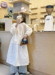 Close-up of girl's denim mini bag with brown plush bear charm and lace embroidery detail