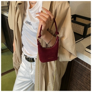 Détail d'un mini sac bordeaux en daim pour fille avec bandoulière chaîne dorée et anse