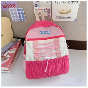 Detailed view of pink and beige school backpack with criss-cross drawstring and Fasbag logo