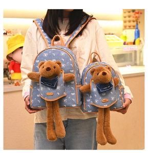 Detail of blue denim backpack set with cute brown plush bears and leather trim