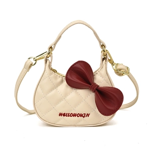 Petit sac bandoulière beige pour enfant avec grand nœud rouge et motif matelassé