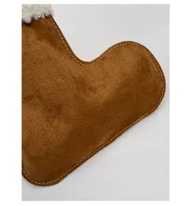 Detail of premium brown suede material with white faux shearling trim and contrast stitching