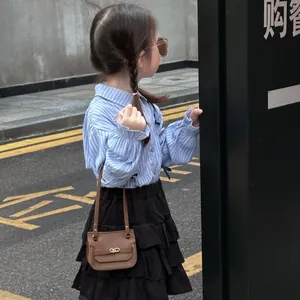 Gros plan sur un mini sac à bandoulière marron texturé avec fermoir en métal pour fille