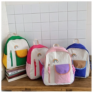 Detail of colorful contrast nylon backpacks with rainbow patches for children