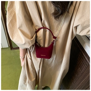 Gros plan d'un mini sac à main bordeaux mat avec bandoulière chaîne pour enfant