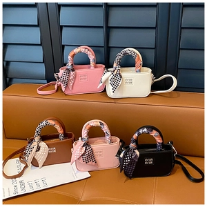 Dettaglio di mini borse a mano con foulard in seta in rosa, bianco, marrone e nero