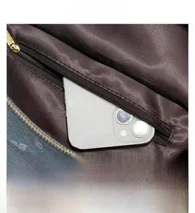 Internal view of denim printed backpack featuring a zippered pocket and smartphone compartment