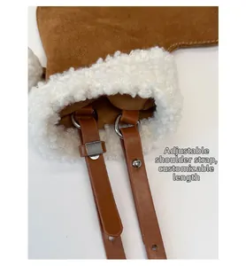 Detail of adjustable leather shoulder strap with silver buckle on a suede crossbody bag