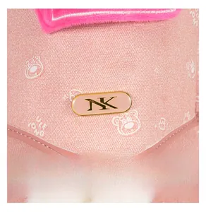 Dettaglio della borsa rosa in maglia con orsetto 3D e placchetta logo in oro