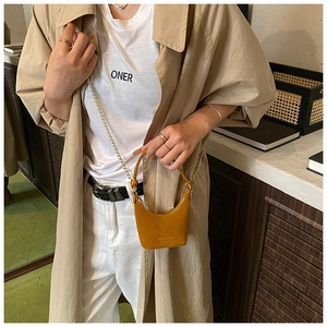 Gros plan détaillé du mini sac à main jaune ambre givré avec chaîne dorée élégante