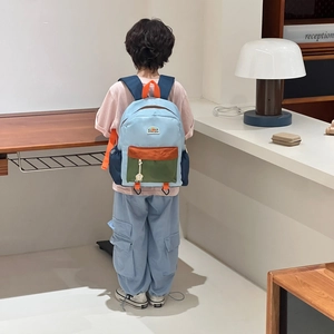 Kids color-block backpack in light blue and green with orange accents for school