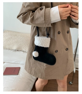 Detail of creative sock-shaped crossbody bag featuring faux fur trim and white pom-pom