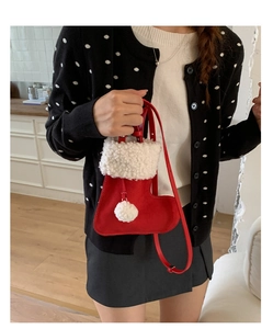 Christmas stocking shaped red crossbody bag with fuzzy white trim worn by a model