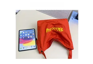Comparaison de taille du sac fourre-tout rouge pour enfants avec une tablette tactile