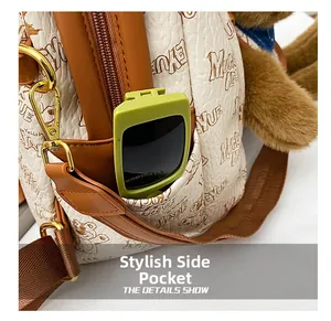 Detail view of the side pocket on a cream leather backpack with cute bear print pattern