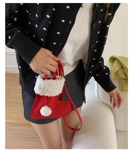 Détail du sac botte de Noël en daim rouge avec bordure en fourrure et pompon blanc