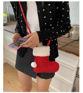 Macro detail of red suede Christmas stocking crossbody bag with white faux fur trim
