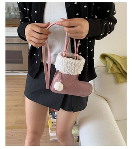 Detail of pink boot-shaped handbag with plush white faux fur trim and soft pom-pom