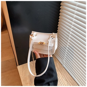 Détail du mini sac blanc motif litchi avec fermoir rotatif doré et bandoulière chaîne