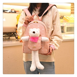 Detailed shot of pink leather backpack with cute 3D plush bear and cartoon prints