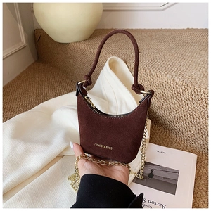 Détail du mini sac en daim marron foncé pour fille avec chaîne dorée et fini mat élégant